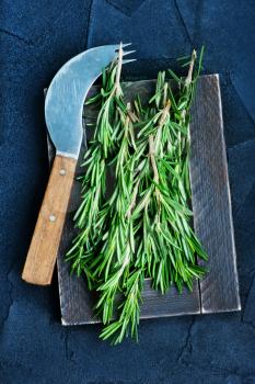 fresh rosemary on board and on a table