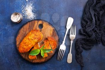 fried chicken breast on wooden board on a table