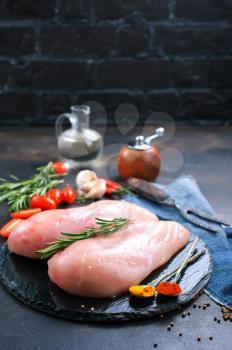 raw chicken with salt and spice, chicken on black board