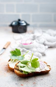 Hearty lard with garlic served with fresh bread on a rustic white table.