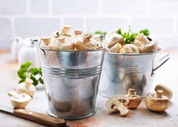 raw mushrooms in metal bucket, champignons in bucket
