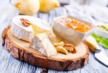 cheese nuts honey and fresh pears on wooden board