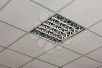 Fluorescent office ceiling lamp built-in on the white ceiling close-up view