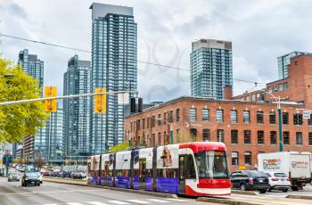 Toronto, Canada - May 2, 2017: Modern streetcar on a street of Toronto. The Toronto streetcar system is the largest and the busiest light-rail system in North America