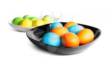 Colorful easter eggs on a black and white plates. Shallow depth of field.