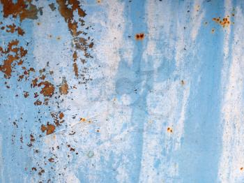 Old blue grunge material. Peeling paint and rust stains. Shallow depth of field.