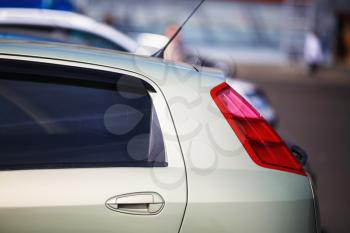 Rear of the modern car. Close-up of a taillight. Auto in the parking lot. Shallow depth of field. Selective focus.