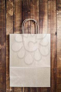 Recycled craft shopping bag on vintage wooden table background.