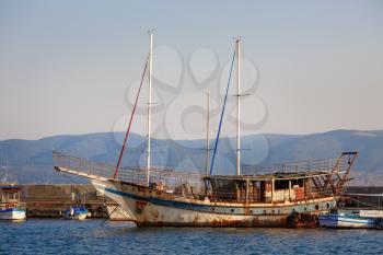 Nesebar, Bulgaria - September 10, 2014: Old rusty ship and boats at the pier in the old town of Nessebar, Bulgaria.
