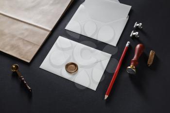 Blank white envelopes with vintage stationery on black paper background.