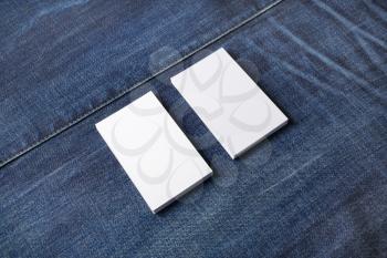 Stacks of white blank business cards on denim background. Template for graphic designers portfolios.