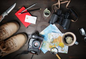 Preparation for travel. Outfit of traveler. Essential vacation items on wood table background. Flat lay.