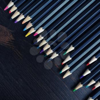 Various colored wooden pencils on wood table background. Flat lay.