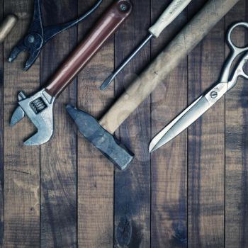 Old used tools on vintage wooden background. Top view. Flat lay.