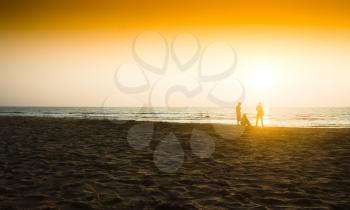 Three friends meeting sunset on ocean beach background