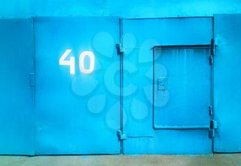 Cyan closed garage door with numer 40 city background