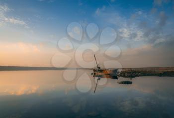 Panoramic view of the lake and the old boat at sunset of a summer day