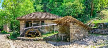 Water mill in the Etar Architectural Ethnographic Complex in Bulgaria on a sunny summer day. Big size panoramic photo.
