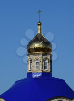 Domes of an Orthodox church. Gold-plated dome, orthodox crosses and blue roof.