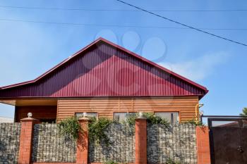 Detached house with a roof made of steel sheets. Roof metal sheets. Modern types of roofing materials.