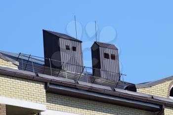 The roof of a multistory building. The roof of the metal sheets, equipped with overflow and exhaust pipes.