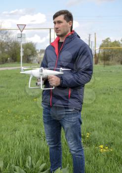 A man with a quadrocopter in his hands. A white drone is being prepared for the flight. Phantom