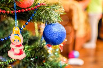 Tinsel and toys, balls and other decorations on the Christmas Christmas tree standing in the open air. Decorations New Year tree.