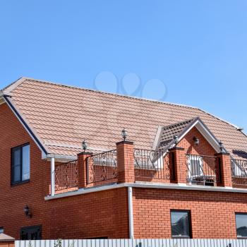 Detached house with a roof made of steel sheets. Roof metal sheets. Modern types of roofing materials.