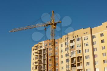 Crane  at construction site against blue sky.