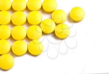 Yellow pills, tablets  on a white background
