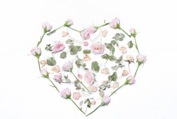 Pink flowers, green leaves in the shape of a heart on a white background. The concept of a holiday of love. pastel style, color trend