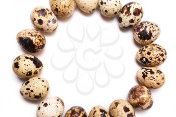 Round frame of quail eggs in a row on a white background. View from above, flat