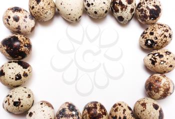 square frame of quail eggs on a white background. View from above, flat
