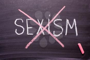 Stop sexism is written on a chalkboard chalk.Concept of equality