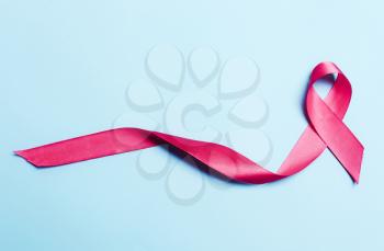 Pink, red ribbon on a blue background. The symbol of a worldwide campaign against breast cancer.