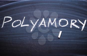 The word polyamorys written on the blackboard with chalk.