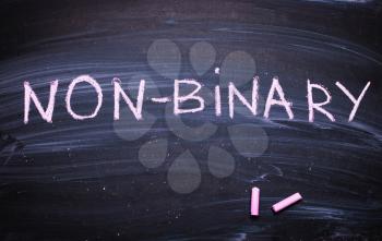 The word Non- binary ,nonbinary is written on a chalk board