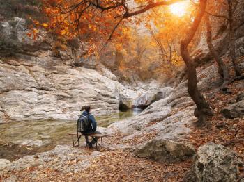 Man sitting on autumn canyon. Relax and emotional scene.