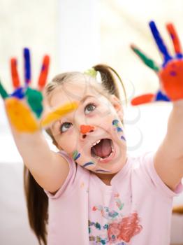 Portrait of a cute cheerful girl showing her hands painted in bright colors