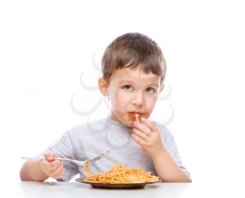 Little boy is eating spaghetti using fork, isolated over white