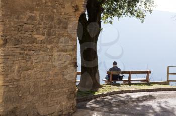 Lonely man sitting on bench with beautiful view of the mountains. The Park and the forest outside the city.