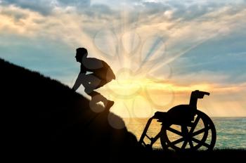 Concept of disability and self-motivated. Silhouette of disabled person to climb the hill on a background of sea sunset