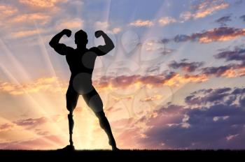 Disabled bodybuilder with prosthesis is posing sunset. Concept handicapped and sport