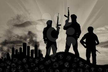 Concept of a terrorist attack. Silhouette of terrorists with a rifle standing on a pile of skulls on the background of the city in smoke