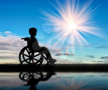 Boy in wheelchair and reflection in water day. Disabled children concept