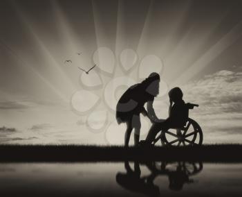 Disabled child in wheelchair crying and his mother on beach and reflection. Concept of disability