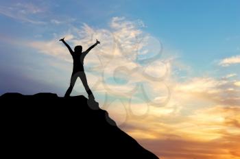 Concept of emotions and feelings. Silhouette of a happy man on the top of a mountain at sunset