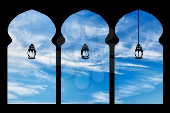 Silhouette arches inside the building of the mosque and lanterns against the sky