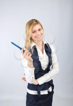 Business woman with a pen in his hand in a suit on a light background