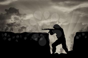 Terrorist with a rifle in trenches with skulls in ground. concept of fight against terrorism